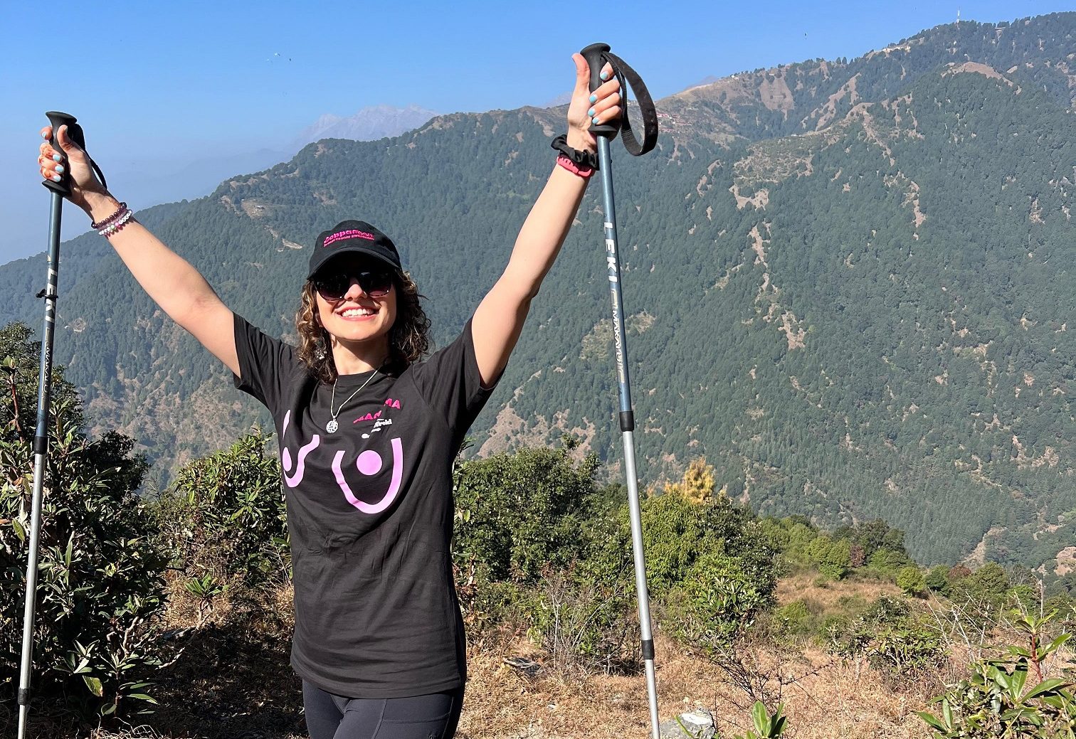 Dalia on top of a mountain celebrating a fundraising hike